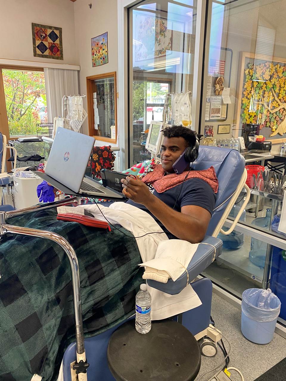 Donor relaxing in a chair with a game and headphones