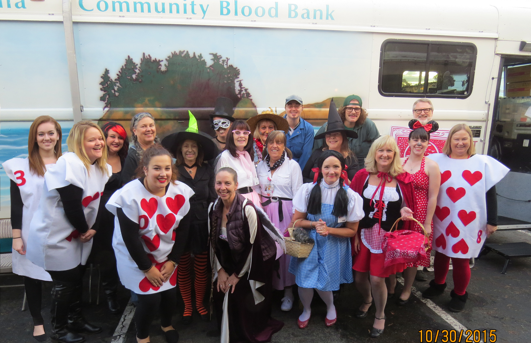 Blood bank staff in costume in front of the Bloodmobile